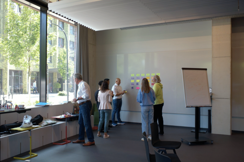 Workshops für Teams: Teilnehmende arbeiten gemeinsam an einer Moderationswand